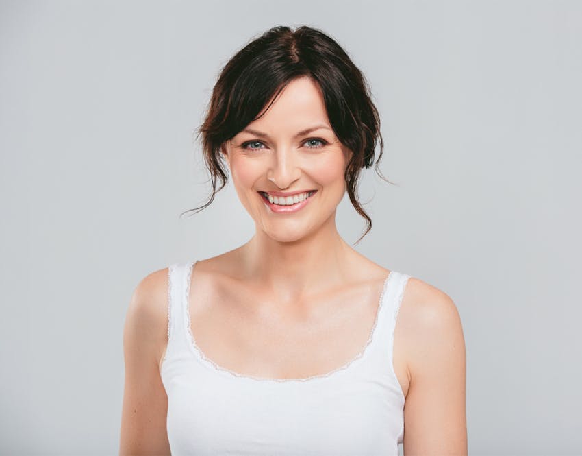 woman smiling in white tank top