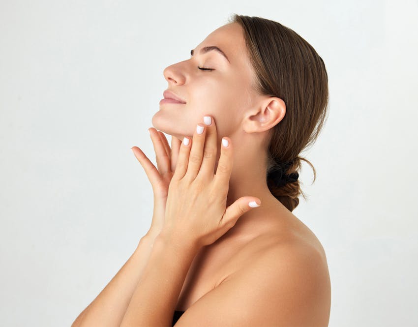 woman touching face with eyes closed