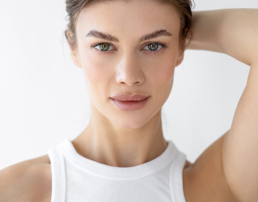 close up of womans face with hand on back of head