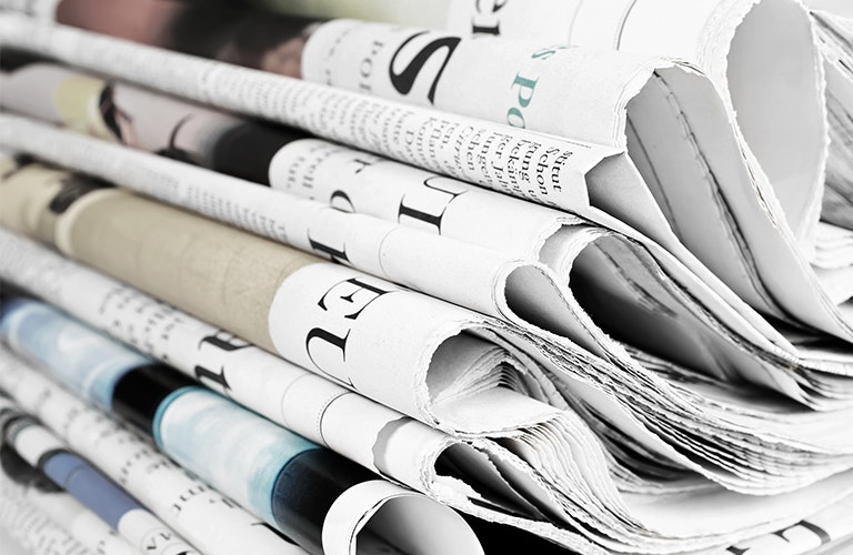 Erudus Newsroom Newspapers Piled Neatly