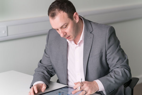 Jon Shayler heads up the Erudus Development Team at Infotech, the developers behind Erudus. Jon Shayler of Erudus at desk looking at digital tablet