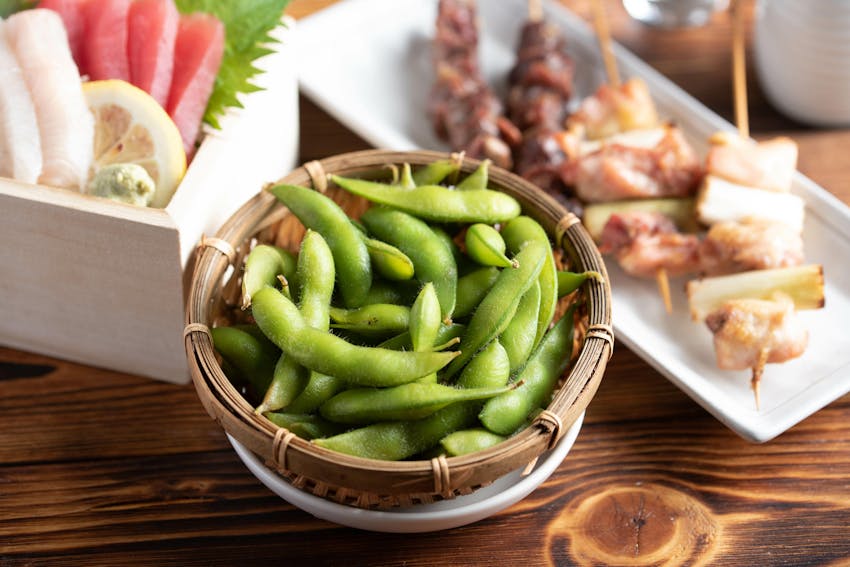 a small wooden bowl of edamame soya beans 