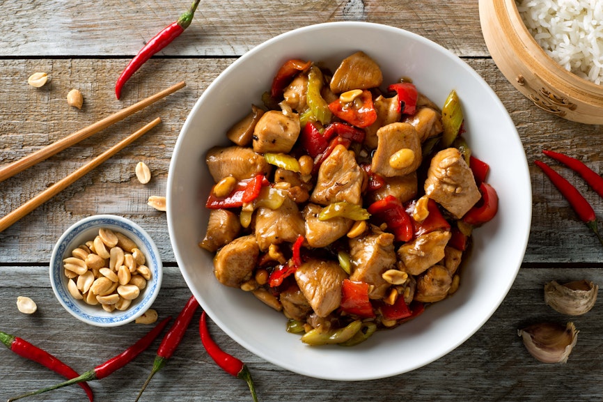 Peanuts are used to garnish and add crunch to many dishes a bowl of satay chilli chicken topped with peanuts