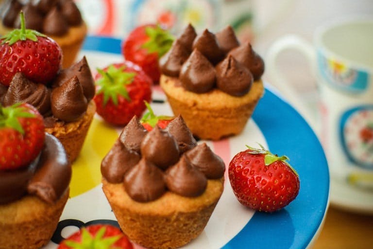 Chocolate Mousse and Caramel Shortbread Cups five chocolate mousse and caramel shortbread cups on a blue plate with red strawberries