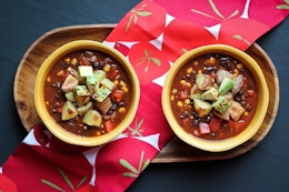 two bowls of vegan chilli with cocoa served on a wooden tray 