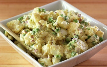 Potato, Bacon & Pea Salad square white dish filled with a creamy potato, bacon and pea salad