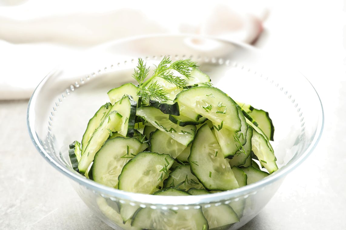 Cucumber & Dill Salad a clear glass bowl filled with green cucumber and dill salad