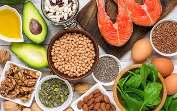 a birds eye flatlay of various nuts seeds beans and avocado spinach eggs and meat 