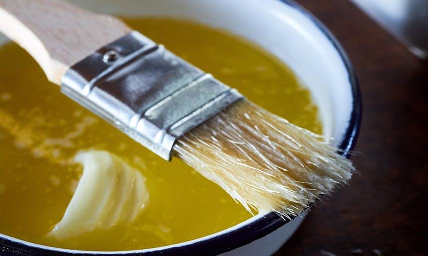 a bowl of butter melted and ready to be used for coating with a coating brush 