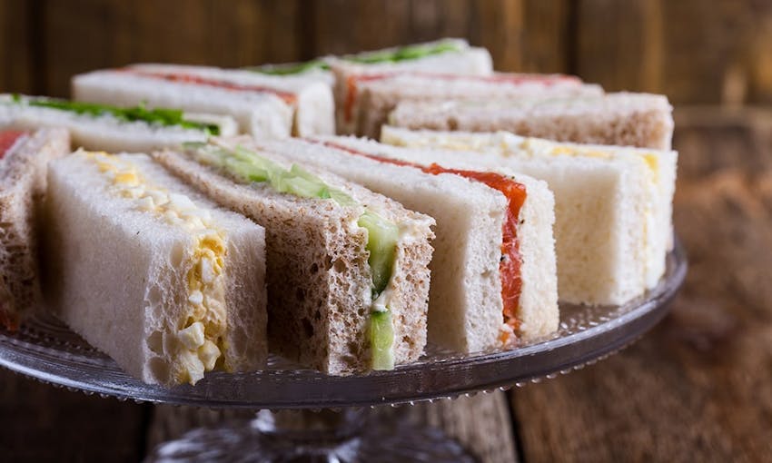 small rectangular cucumber, salmon and cream cheese and egg mayonnaise sandwiches on a tiered platter 