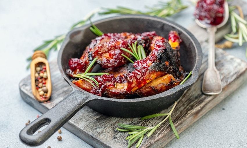 Cook your cherries down into a sauce and use to glaze meat dishes a small skillet with fried chicken wings glazed with a cherry reduction on top of a chopping board and decorated with fresh herbs salt and pepper