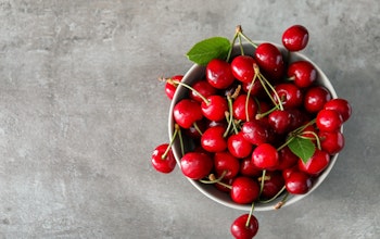 birds eye view of a bowl filled with red cherries on top of a marble table 