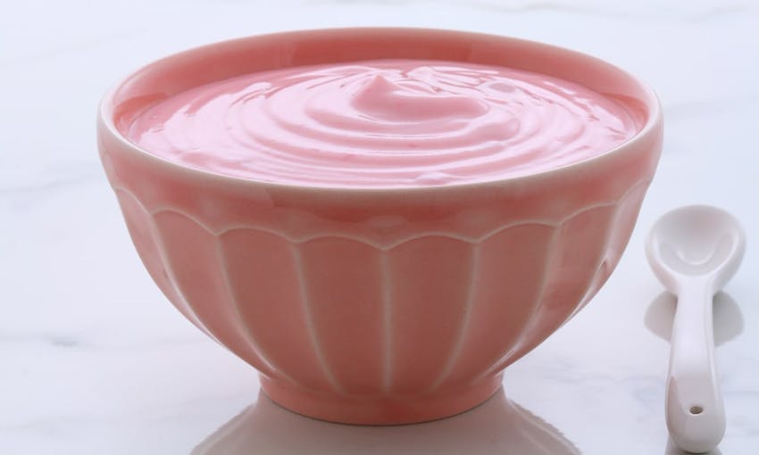 a small pink bowl of light and silky pink frozen custard with a small white serving spoon 