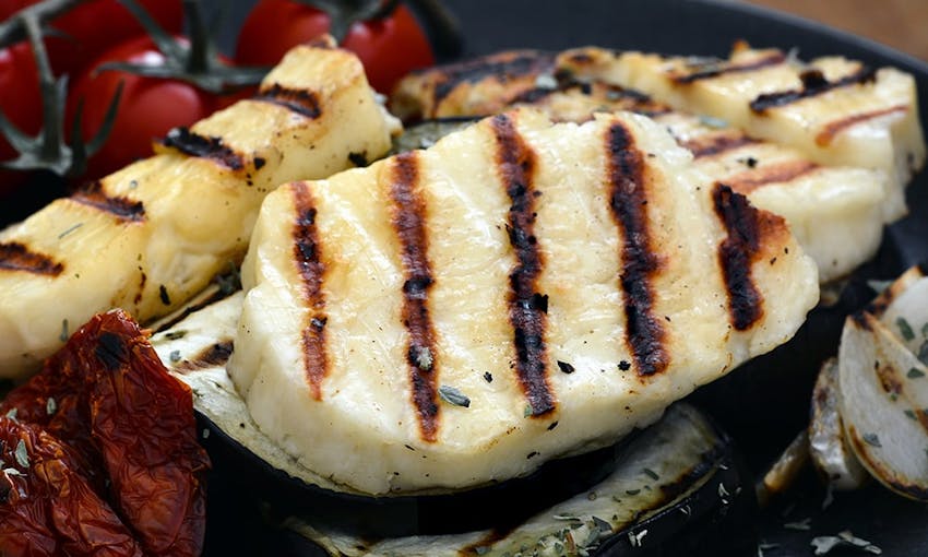 thick slices of chargrilled halloumi next to vine cherry tomatoes 