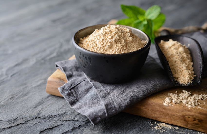 a small dark bowl of maca powder 