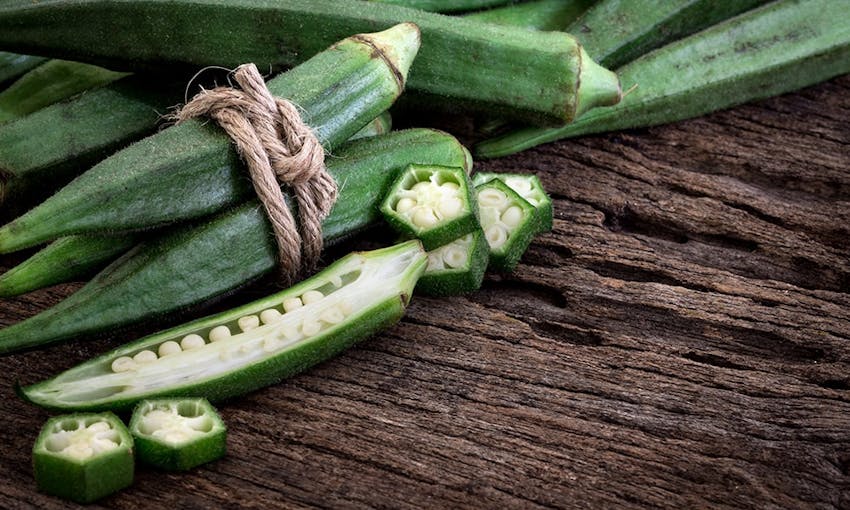 stalks of okra tied up with brown string and a stalk of okra cut in half 