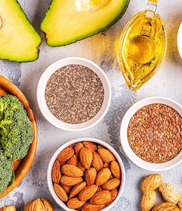 Healthy Staples for your diet. healthy dishes consisting of avocado, broccoli, seeds, nuts and vegetables on a wooden table