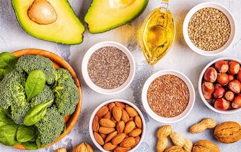 healthy dishes consisting of avocado, broccoli, seeds, nuts and vegetables on a wooden table 