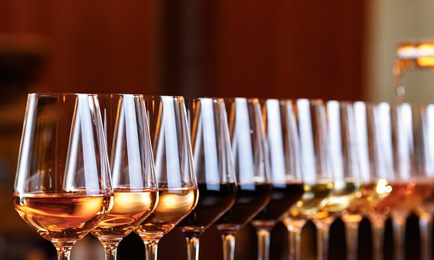 A range of different wines twelve wine glasses in a diagonal line
