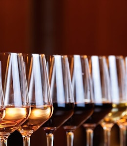 A range of different wines twelve wine glasses in a diagonal line