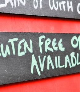 Menu board with  wooden gluten free options available sign 