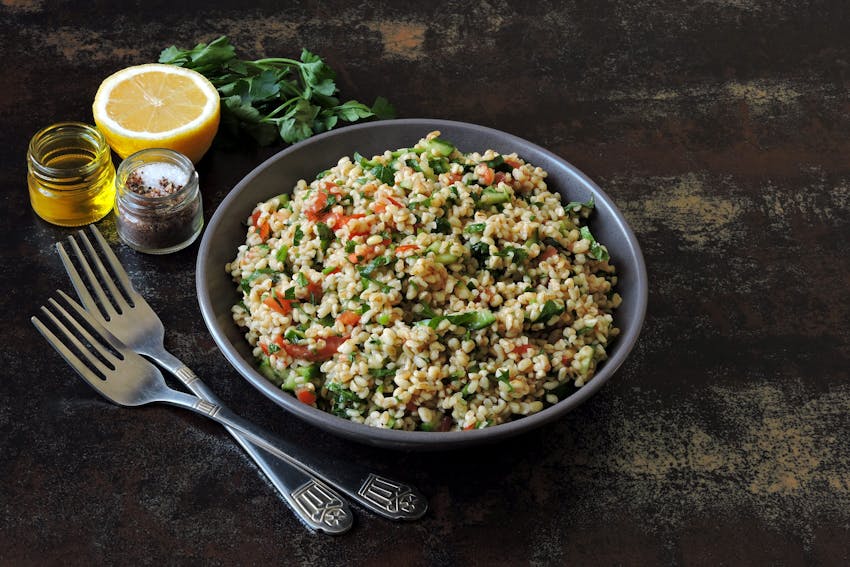 a bowl of chopped parsley, tomatoes, mint, onion, soaked bulgar, olive oil, lemon juice, salt and pepper 