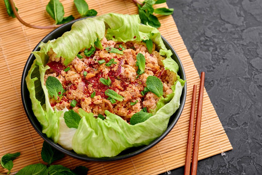 a salad of lettuce, minced meat, chilli, lime, onion and herbs