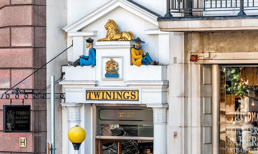 white twinings store front with golden lion and english lions shield with two figurines sat above entrance 