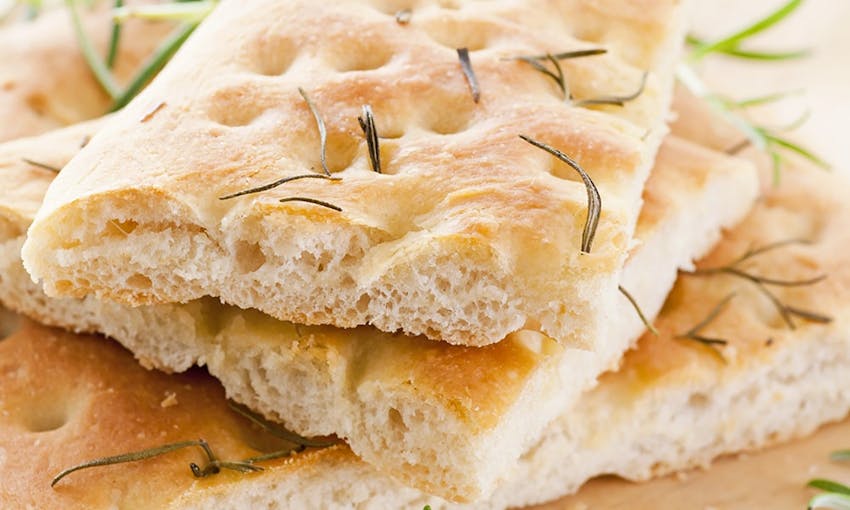 a stack of focaccia topped with herbs 