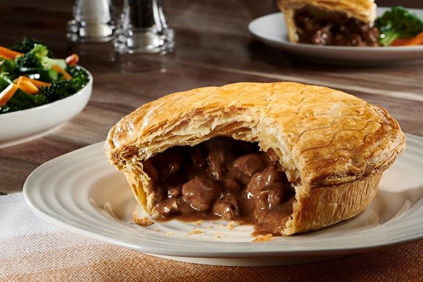 a large sliced open steak and ale pukka pie with meat and filling oozing out 