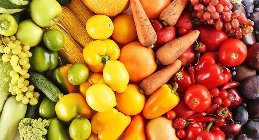 colourful spectrum of fruits and vegetables going from green through to yellow through to orange to red and then purple 