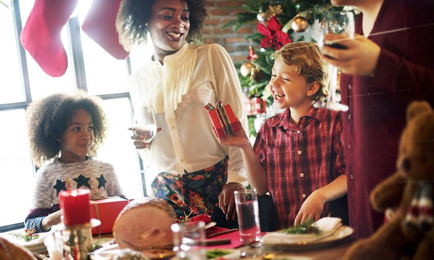 family and friends gathered around the table for christmas dinner 