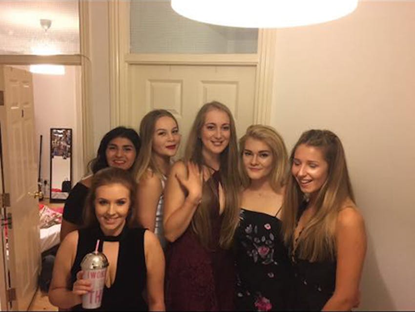 a group of young girls in a university house before a night out 