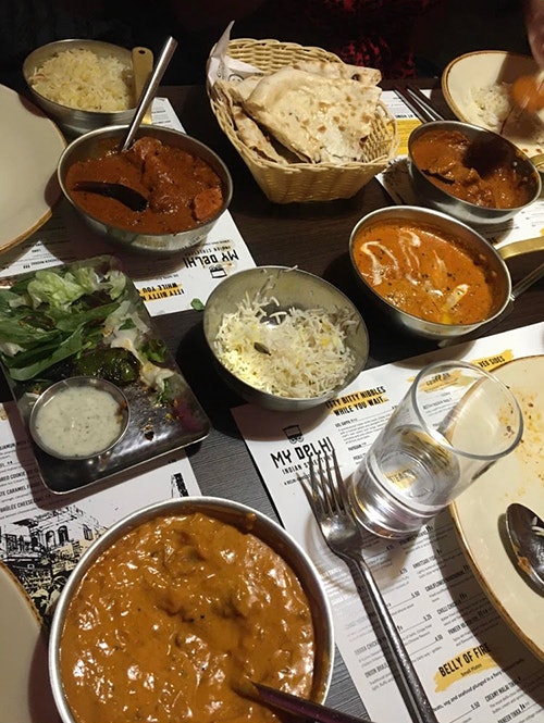 varying plates and trays of indian dishes 