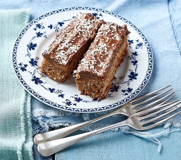 JimJams Chocolate & Coconut Slice two rectangular sweet chocolate and coconut slices on a blue and white china plate on a light blue tablecloth