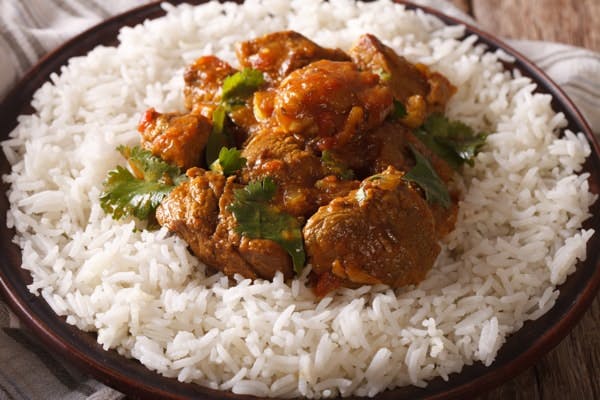 rogan josh lamb curry on a bed of white fluffy rice 