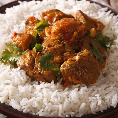 rogan josh lamb curry on a bed of white fluffy rice 