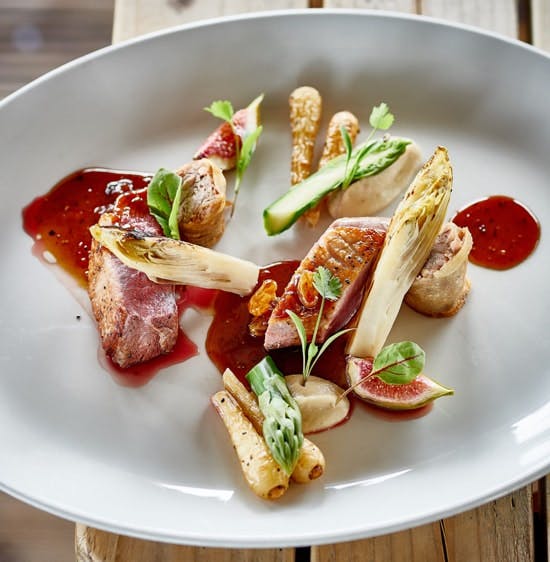 an a la carte style dish of duck breast, charred chicory and figs drizzled with fig and date jus 