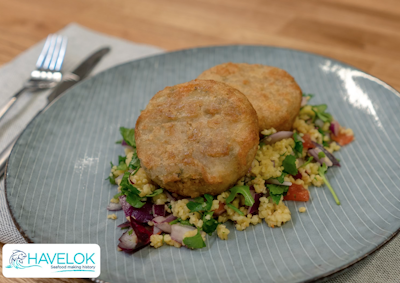 two crispy pollock fishcakes on a bed of Moroccan tabbouleh on a grey plate 