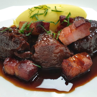 Braised Beef in a Red Wine and Port jus with creamy mash potato topped with fresh herbs 