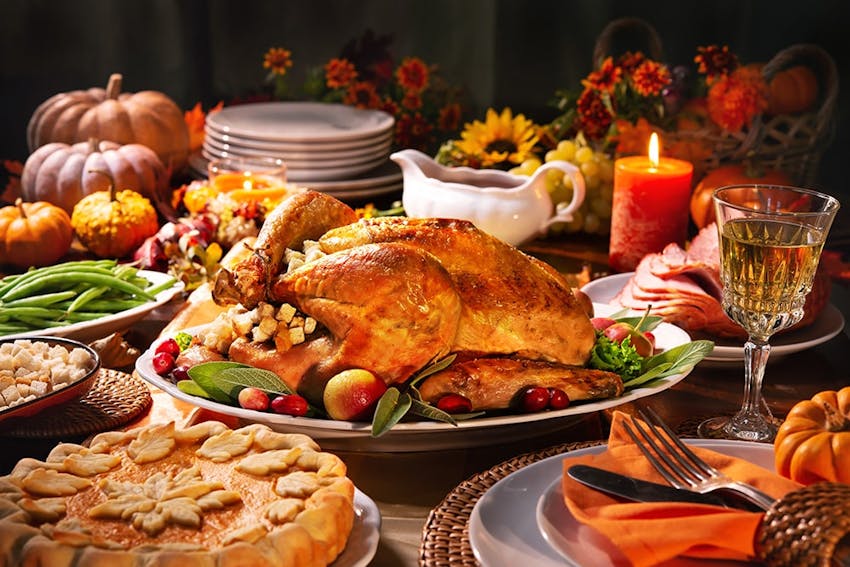 christmas dinner with a turkey centrepiece, festive pie, green beans, gravy, honey roast ham and decorative flowers