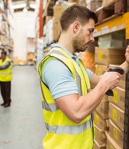 Warehouse A man in a high vis searching the GTINs of products in a large warehouse