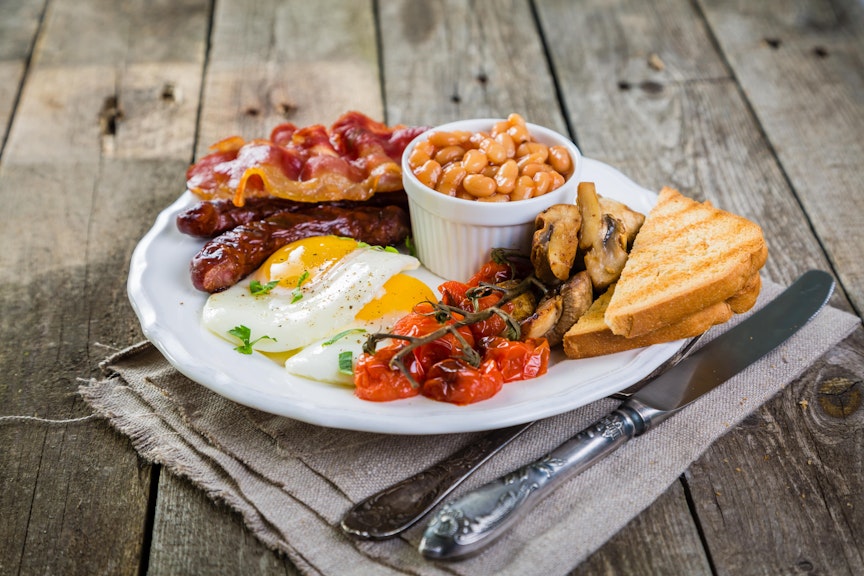 Make Your English Breakfast Stand Out big english breakfast consisting of a pot of baked beans, brown bread, vine tomatoes, mushrooms, eggs, bacon and sausages
