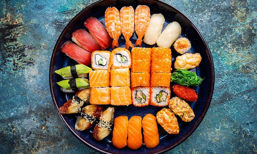 black dished filled with symmetrically placed colourful sushi 
