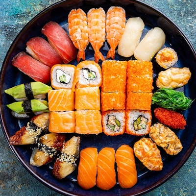 black dished filled with symmetrically placed colourful sushi 
