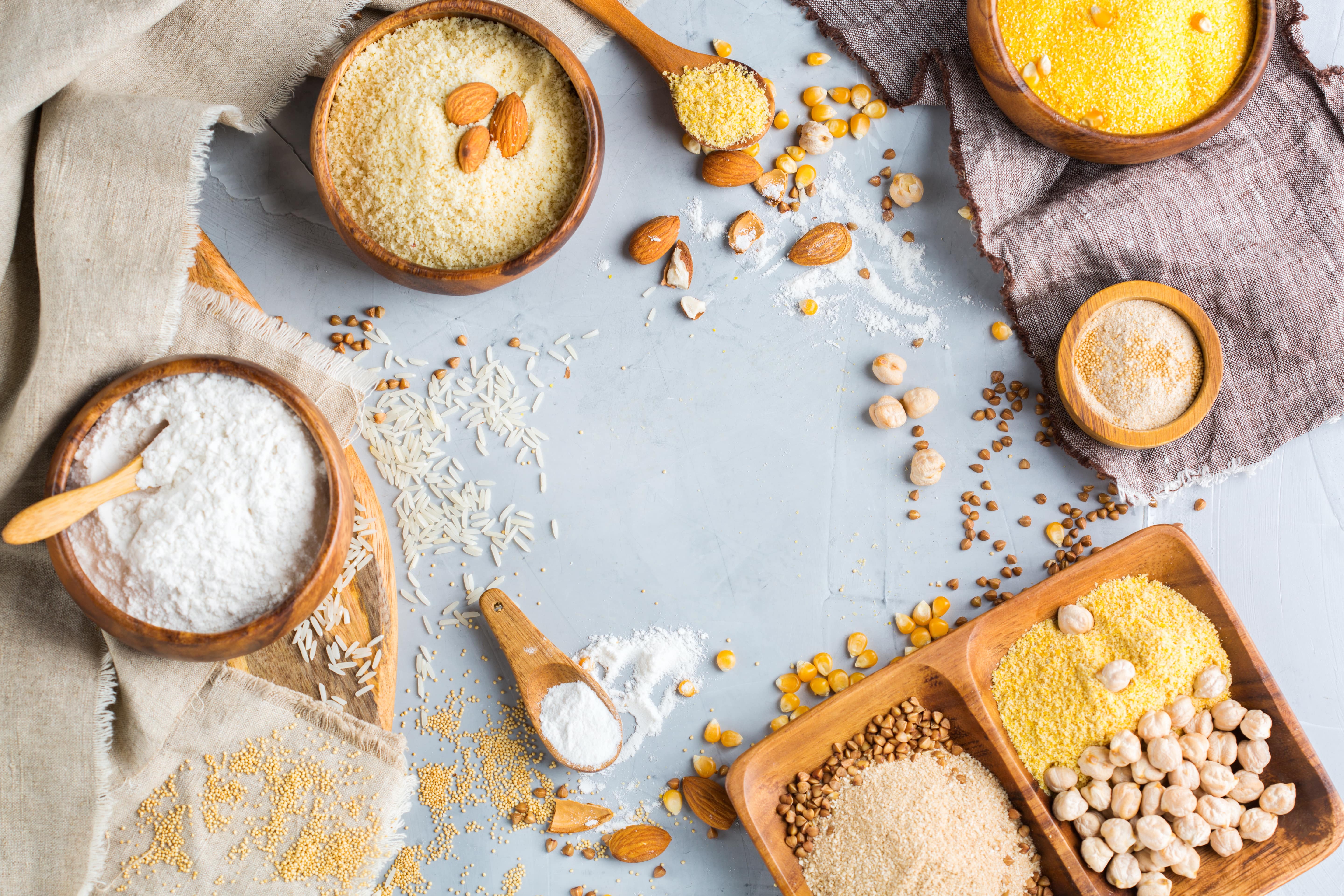 flatlay of wooden bowls filled with various different grains containing gluten 