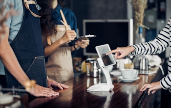 customer orders food in a restaurant on an ipad infront of waiting staff 