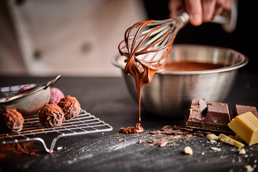 Milk and butter are often used in cake icing woman holding a whisk that has dairy free chocolate icing dripping onto the cooking work top