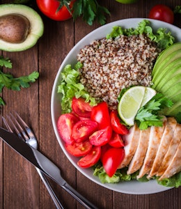 a healthy dish made up of avocado, salmon, whole grains, tomato and salad