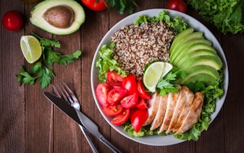 a healthy dish made up of avocado, salmon, whole grains, tomato and salad